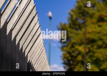 Nahaufnahme der Spitze eines schwarzen Metallzauns gegen Der blaue Himmel an einem sonnigen Tag Stockfoto