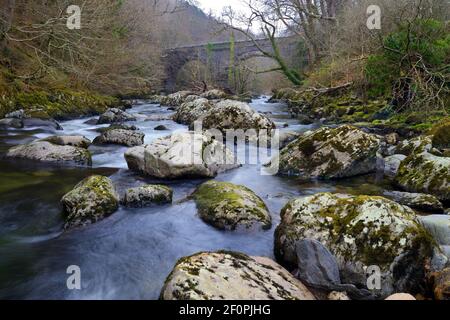 Der Ogwen-Fluss entspringt im Ogwen-See in Snowdonia, ist aber hier in seinem unteren Bereich nahe dem alten Eisenbahnviadukt bei Tregarth zu sehen. Stockfoto