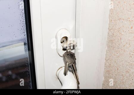 Schlüssel im Schloss einer weißen Kunststofftür Stockfoto