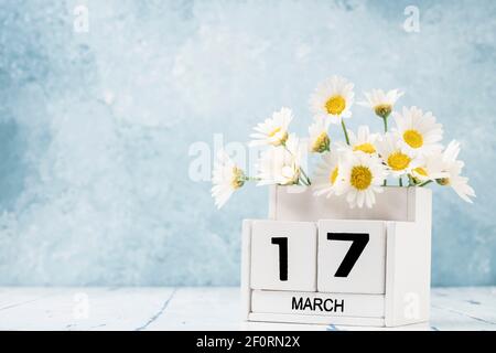 White Cube Kalender für märz mit Gänseblümchen über geschmückt Blauer Hintergrund mit Kopierbereich Stockfoto