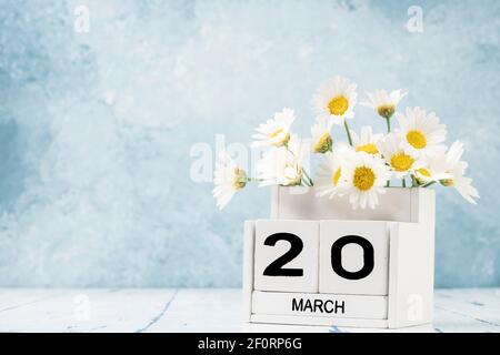 White Cube Kalender für märz mit Gänseblümchen über geschmückt Blauer Hintergrund mit Kopierbereich Stockfoto