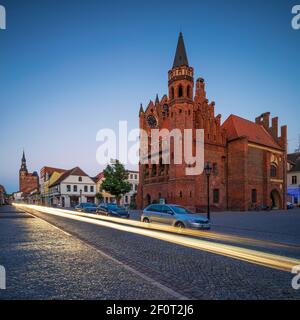 Rathaus und Kirche St. Stephan in der Abenddämmerung, leichte Spur von Auto auf Kopfsteinpflasterstraße, Tangermünde, Sachsen-Anhalt, Deutschland Stockfoto
