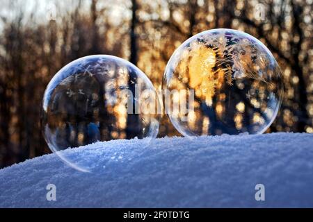 Eiskalte Seifenblasen mit Eiskristallen auf Schnee im Backlight, Deutschland Stockfoto