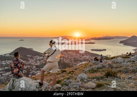 Dubrovnik, Kroatien - Aug 21, 2020:zwei männliche bewundern den Sonnenuntergang über der Küste der Adriatischen Inseln im Sommer vom Berg SRD Stockfoto