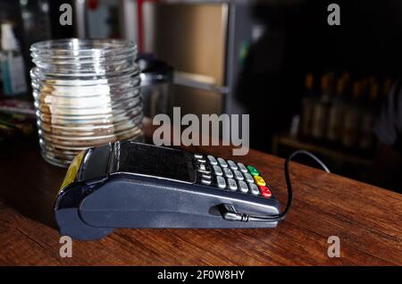 Das Zahlungsterminal für Kreditkarten befindet sich auf dem Tisch im Café des Cafés. Nahaufnahme des kontaktlosen Bezahlgeräts, des Kartenautomaten Stockfoto