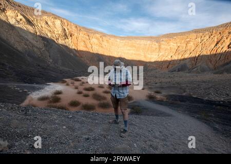 Die Wanderung hinunter zum Ubehebekrater im Death Valley National Park ist schnell. Die Wanderung hinauf und aus dem Krater ist steil und schwierig. Stockfoto