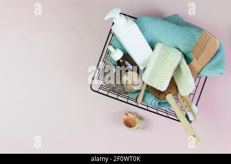 Set von Duschzubehör in einem Korb auf einem Marmorboden. Enthält Flaschen von Kosmetika, Loofa, Zahnbürsten, Handtuch. DIY Öko-Kosmetik. Konzept z Stockfoto