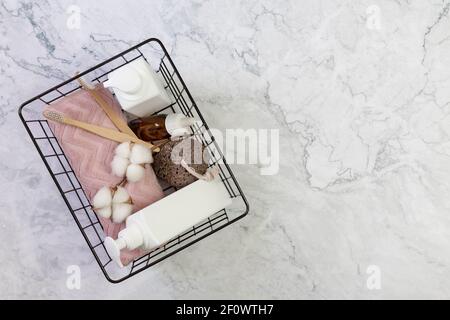 Self-Care-Kit für Körper, Haar, Gesicht, Dusche Zubehör in einem Korb auf einem Marmorboden. Konzept Null Abfall, nachhaltig. Copy Space. Flach legen Stockfoto