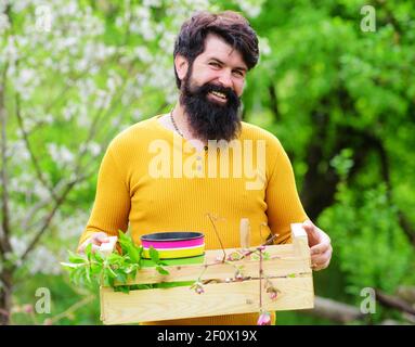Frühjahrsgärtner. Lächelnder Mann, der sich für die Pflanzung vorbereitet. Arbeiten im Garten. Gärtnerarbeit. Stockfoto