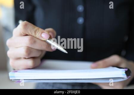 Weibliche Hand macht Notizen mit Stift im Notizbuch Stockfoto