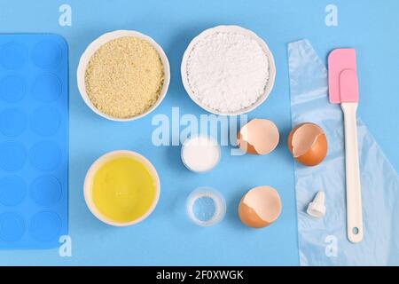 Zutaten für die Herstellung von hausgemachten französischen Macarons Süßigkeiten einschließlich Puderzucker, gemahlenen Mandeln, Eiweiß, Salz und Backwerkzeuge wie Schimmelmatte Stockfoto