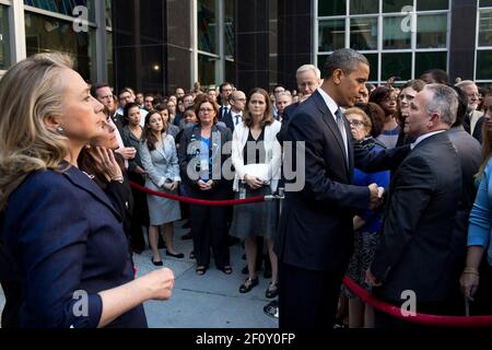 Präsident Barack Obama schüttelt die Hände, nachdem er Mitarbeiter des Außenministeriums in einem Innenhof des Außenministeriums in Washington D.C. angesprochen hatte. Sept. 12 2012. Außenministerin Hillary Rodham Clinton steht links. Stockfoto