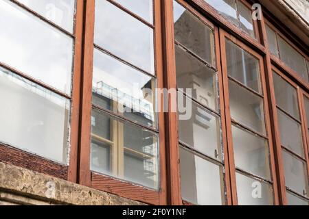 Verwitterte Holzfenster des Balkons eines historischen Gebäudes. Nahaufnahme Stockfoto