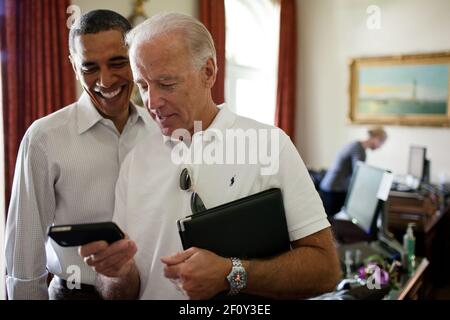 Vizepräsident Joe Biden und Präsident Barack Obama betrachten eine App auf einem iPhone im Outer Oval Office Samstag, den 16 2011. Juli. Stockfoto