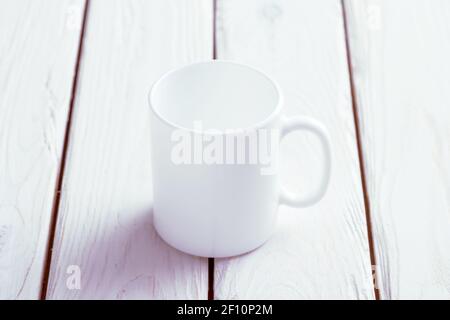 Weiße Tasse Nachbau auf Holztisch Stockfoto