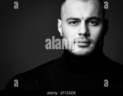Portrait von lächelnd gut aussehenden brutalen Mann in schwarz jamper suchen Bei der Kamera Stockfoto