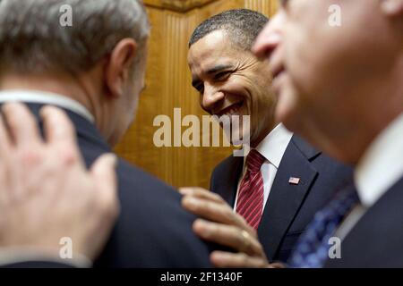 Präsident Barack Obama und Vizepräsident Joe Biden gratulieren Phil Schiliro, dem Assistenten des Präsidenten für Legislative Angelegenheiten, zur Verabschiedung des Gesetzes zur Gesundheitsreform, während sie am 21. März 2010 mit dem Aufzug zur Residenz des Weißen Hauses fahren. Stockfoto