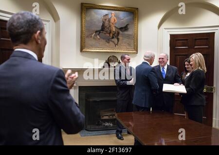 Präsident Barack Obama applaudiert, als Vizepräsident Joe Biden nach einer Vereidigung im Roosevelt Room des Weißen Hauses am 8 2013. März die Hände mit dem CIA-Direktor John Brennan schüttelt. Stockfoto