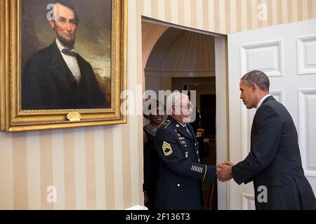 Präsident Barack Obama begrüßt den Ehrenmedaillenempfänger Stabsfeldwebel Melvin Morris und seine Familie im Oval Office, 18. März 2014. Stockfoto