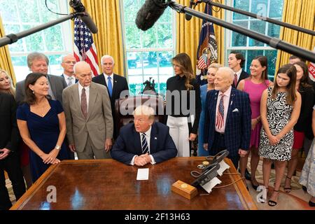 Präsident Donald Trump und First Lady Melania Trump und Vizepräsident Mike Pence sprechen zu Reportern während einer Gedenkfotogelegenheit mit Apollo 11 Astronauten Buzz Aldrin und Michael Collins ihre Familienmitglieder und die Familie von Neil Armstrong Freitag, den 19 2019. Juli während einer Feier des 50th Jahrestag der Mondlandung von Apollo 11 im Oval Office des Weißen Hauses. Stockfoto