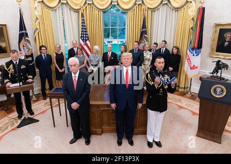 Präsident Donald Trump steht bei der Zitationslesung für Presidential Medal of Freedom Empfänger legendäre Rennfahrer und Rennteam-Besitzer Roger Penske Donnerstag, 24 2019. Oktober im Oval Office des Weißen Hauses. Stockfoto