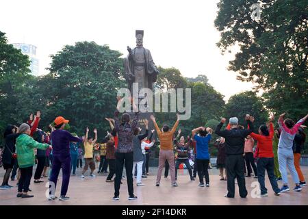 Vietnamesisches Leben. Hanoi Bewohner trainieren am frühen Morgen unter der großen Bronzestatue von König Ly Thai, in der Nähe von Hoam Kiem See, Hanoi, Vietnam Stockfoto