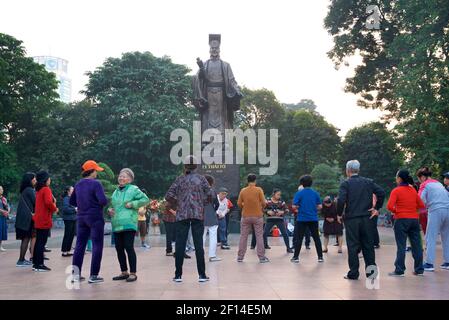 Vietnamesisches Leben. Hanoi Bewohner trainieren am frühen Morgen unter der großen Bronzestatue von König Ly Thai, in der Nähe von Hoam Kiem See, Hanoi, Vietnam Stockfoto