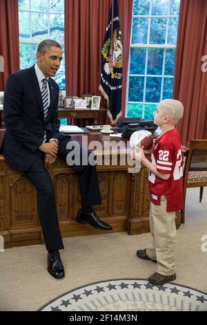 Präsident Barack Obama begrüßt den 7-jährigen Jack Hoffman von Atkinson Nebr. Im Oval Office April 29 2013. Hoffman, der gegen pädiatrischen Hirntumor kämpft, gewann nationale Aufmerksamkeit, nachdem er während eines Frühjahrs-Fußballspiels in Nebraska Cornhuskers für einen 69-Yard-Touchdown lief. Hoffman hält einen Fußball, den der Präsident für ihn unterzeichnete. Stockfoto