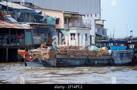 Boot und Flussuferwohnungen auf dem Mekong Fluss, Cai Be, Tien Giang Provinz, Mekong Delta, Vietnam Stockfoto