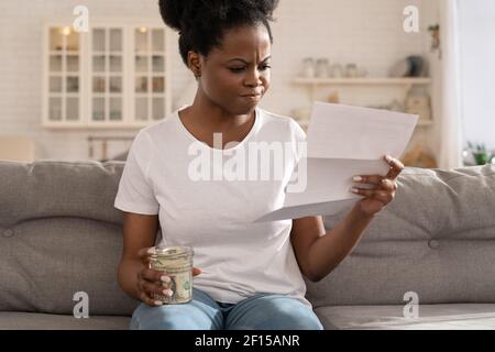 Afrikanische Frau frustriert über Mangel an Finanzen, Gefühl Angst über überfällige Hypothekenzahlung. Stockfoto