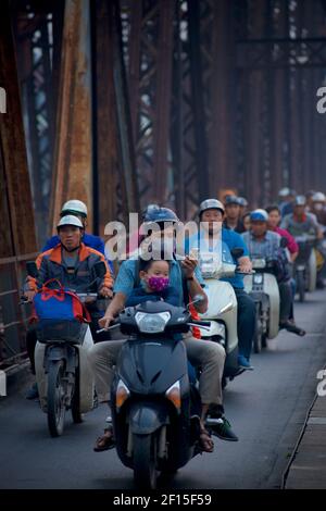 Vietnamesische Stadtpendler auf Motorrädern über die historische lange Bien-Brücke, Hanoi, Vietnam. Stockfoto