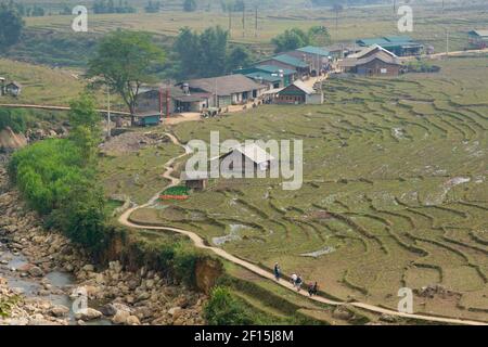 Ländliche Landschaft rund um Sapa, Lao Cai Provinz, Nordvietnam. Ein paar mtorcycle fahren entlang terrassenförmig angelegter Reisfelder. Stockfoto