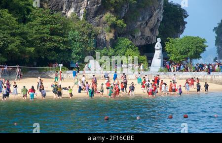 Touristen genießen einen Strand auf Ti Top Insel, Halong Bay, Nordvietnam. Statue des Kosmonauten Gherman Titov im Hintergrund. Stockfoto