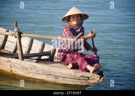 Vietnamesische Frau in markanten konischen Hut in einem kleinen Boot auf dem Thu Bon Fluss, Hoi an, Vietnam. Stockfoto