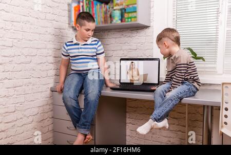 Zwei glückliche kleine Freunde. Jungen, die zu Hause ein intelligentes digitales Tablet nutzen. Stockfoto