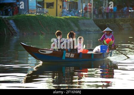 Vietnamesische Familie, die entlang eines Kanals vor dem Thu Bon Fluss, Hoi an, Vietnam Stockfoto