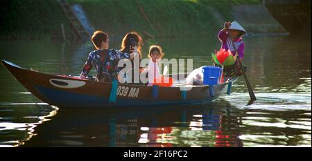 Vietnamesische Familie, die entlang eines Kanals vor dem Thu Bon Fluss, Hoi an, Vietnam Stockfoto