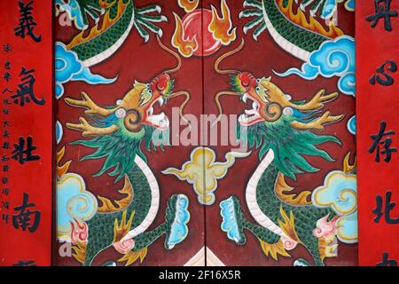 Kunstvoll bemalte Drachen an den Türen zur Quan Cong Pagode. Chua Ong Tempel, Hoi An, Vietnam Stockfoto