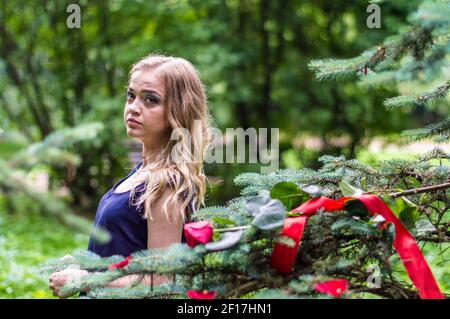 Schönes Mädchen mit Rose und rotem Band Stockfoto