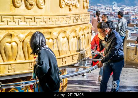 Shangrila China , 8. Oktober 2020 : Chinesischer Tourist, der das riesige tibetisch-buddhistische Gebetsrad des Dafo-Tempels in der Dukezong Altstadt in Shangri dreht Stockfoto