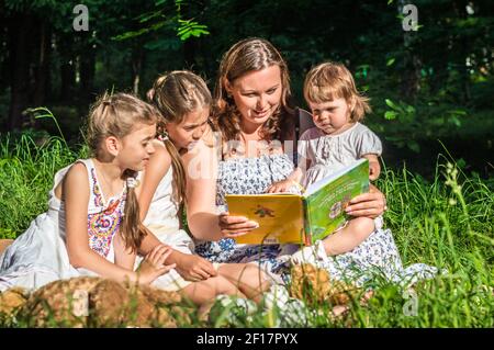 Mutter liest Buch mit Töchtern Stockfoto