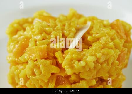 Risotto, fertige Portion Schritt-für-Schritt-Rezept in einem Vintage-Teller auf einem Holzhintergrund Stockfoto