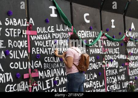 MEXIKO-STADT, MEXIKO - MÄRZ 7: Eine Frau nimmt an einer Performance feministischer Gruppen Teil, um Namen von Opfern von Frauenmorden zu schreiben und Blumen aus Protest gegen geschlechtliche Gewalt zu platzieren, im Rahmen der Proteste des Internationalen Frauentags im Nationalpalast am 7. März 2021 in Mexiko-Stadt, Mexiko. Foto von Luis Barron/Eyepix/ABACAPRESS.COM Stockfoto