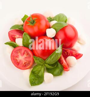 Mozzarella, Kirschtomaten und frisches Basilikum - Zutaten für den Caprese-Salat. Stockfoto