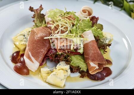 Fleischsalat mit Schinken Käse Salat Dorblin Trauben und Oliven Öl Stockfoto