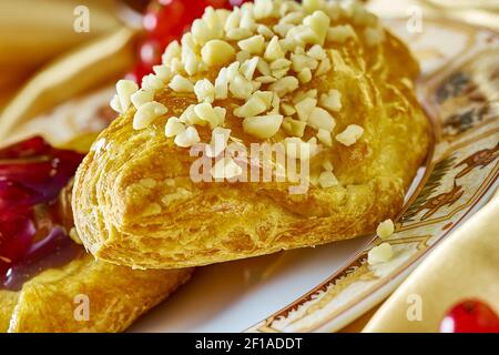 Käsekuchen mit Marmelade auf einem Teller vor dem Hintergrund Die Tasse mit einem Zweig der roten Johannisbeeren Serie voll Kochen von Rezepten Stockfoto