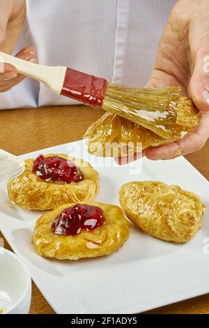 Cook Bürste schmiert Käsekuchen Serie voll Kochen Lebensmittel Rezepte Stockfoto