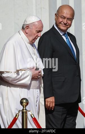 Bagdad, Irak. März 2021, 08th. Der irakische Präsident Barham Saleh (R) begleitet Papst Franziskus zu seinem Alitalia Airbus A330 Flugzeug während seiner Abflugszeremonie am internationalen Flughafen Bagdad zum Abschluss seiner viertägigen Reise in den Irak. Quelle: Ameer Al Mohammedaw/dpa/Alamy Live News Stockfoto