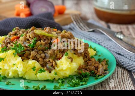 Veganes Gericht mit Kartoffelpüree mit Hafermilch, Linseneintopf und Gemüse. Stockfoto