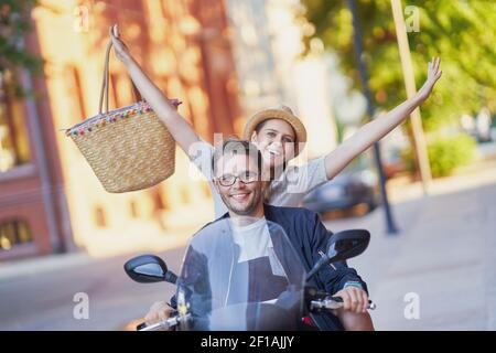 Glückliches reifes Paar, das einen Roller in der Stadt auf fährt Ein sonniger Tag Stockfoto